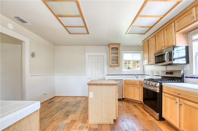 128 N Mason St, Arroyo Grande, CA 93420 - kitchen with stainless steel appliances, light brown cabinets, a wainscoted wall, a center island, and light wood finished floors