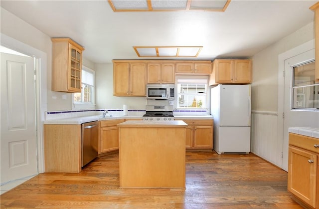 128 N Mason St, Arroyo Grande, CA 93420 - kitchen with appliances with stainless steel finishes, glass insert cabinets, a kitchen island, light brown cabinetry, and wainscoting
