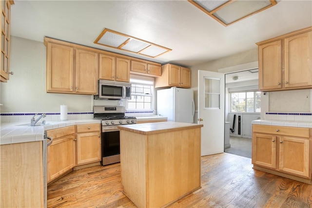 128 N Mason St, Arroyo Grande, CA 93420 - kitchen featuring stainless steel appliances, tile countertops, light brown cabinetry, and light wood-style floors