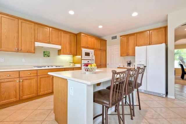 118 Double Eagle, Escondido, CA 92026 - kitchen with white appliances, arched walkways, light countertops, a kitchen breakfast bar, and recessed lighting