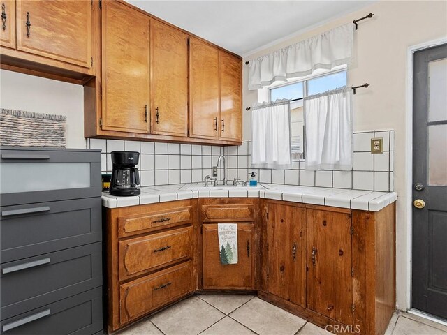 334 N Lomita St, Burbank, CA 91506 - kitchen with brown cabinets, tasteful backsplash, light tile patterned flooring, and tile countertops