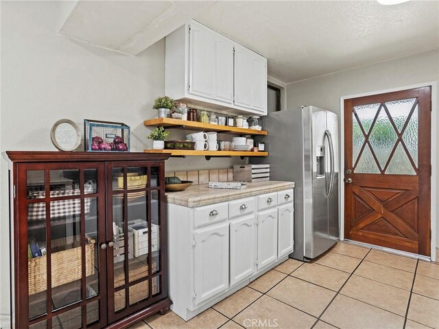 334 N Lomita St, Burbank, CA 91506 - kitchen featuring stainless steel fridge with ice dispenser, white cabinets, light tile patterned flooring, and light countertops