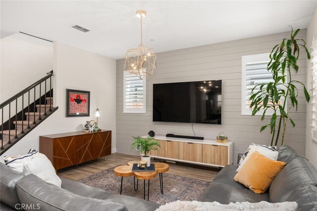 27 Bentwater Loop, Chico, CA 95973 - living room with a chandelier, dark wood finished floors, stairs, and wood walls