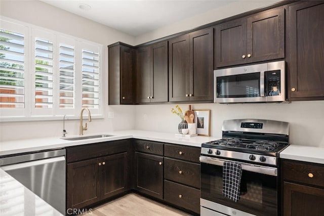 27 Bentwater Loop, Chico, CA 95973 - kitchen with stainless steel appliances, dark brown cabinets, light countertops, and light wood-style flooring