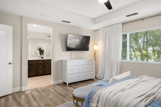 27 Bentwater Loop, Chico, CA 95973 - bedroom featuring light wood-style floors, a tray ceiling, ensuite bathroom, and ceiling fan