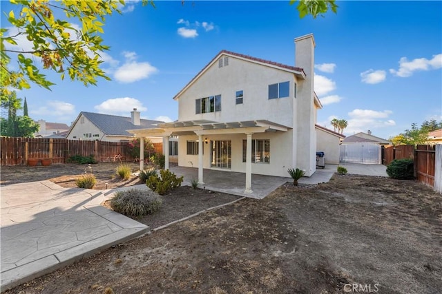 2892 Chuckwagon Rd, Palmdale, CA 93550 - rear view of house with stucco siding, a patio, a chimney, and a fenced backyard