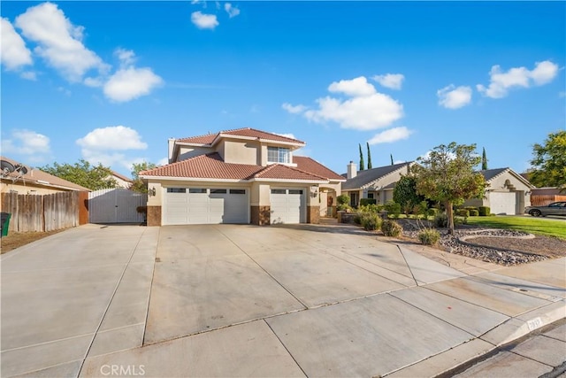 2892 Chuckwagon Rd, Palmdale, CA 93550 - mediterranean / spanish-style house featuring stucco siding, a tile roof, a gate, an attached garage, and driveway