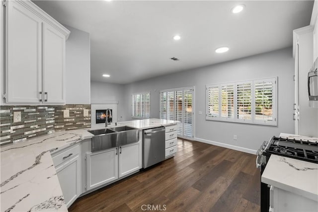 2892 Chuckwagon Rd, Palmdale, CA 93550 - kitchen with stainless steel appliances, white cabinetry, dark wood finished floors, recessed lighting, and plenty of natural light