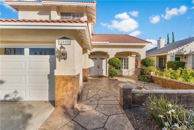 2892 Chuckwagon Rd, Palmdale, CA 93550 - doorway to property with a tiled roof, stucco siding, and concrete driveway
