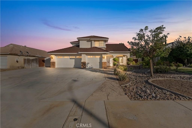 2892 Chuckwagon Rd, Palmdale, CA 93550 - mediterranean / spanish-style house with stucco siding, driveway, an attached garage, and a tiled roof