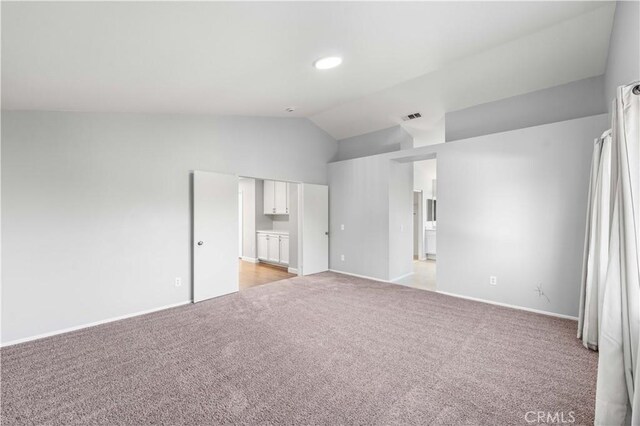 2892 Chuckwagon Rd, Palmdale, CA 93550 - unfurnished bedroom with light colored carpet, vaulted ceiling, and ensuite bathroom
