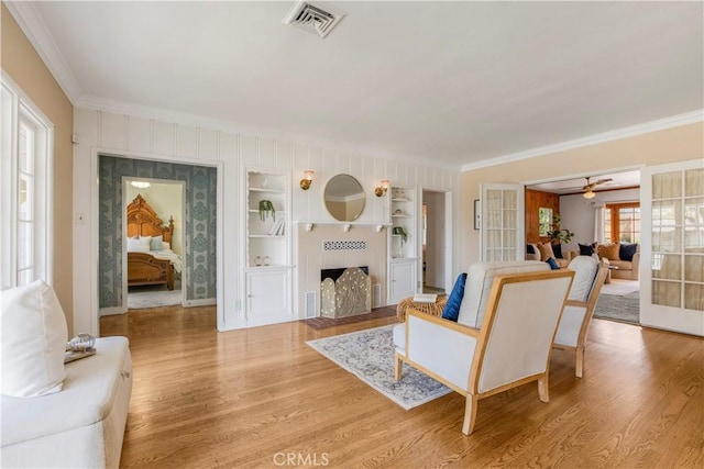 695 W 13th St, Upland, CA 91786 - living room featuring ornamental molding, light wood finished floors, a ceiling fan, a fireplace with flush hearth, and french doors