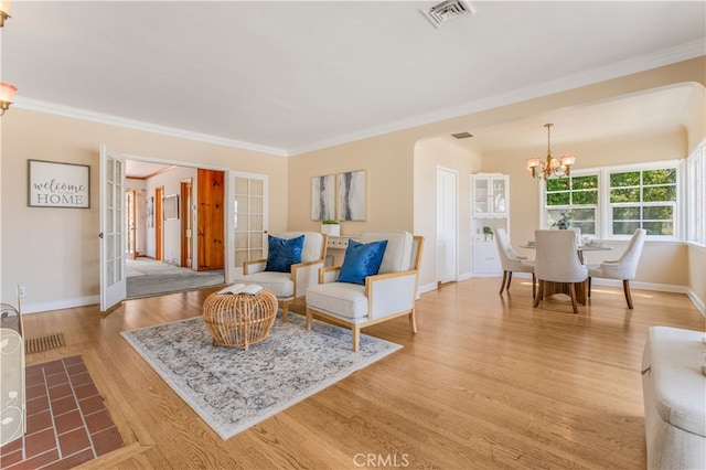 695 W 13th St, Upland, CA 91786 - living area with a chandelier, light wood finished floors, ornamental molding, french doors, and arched walkways
