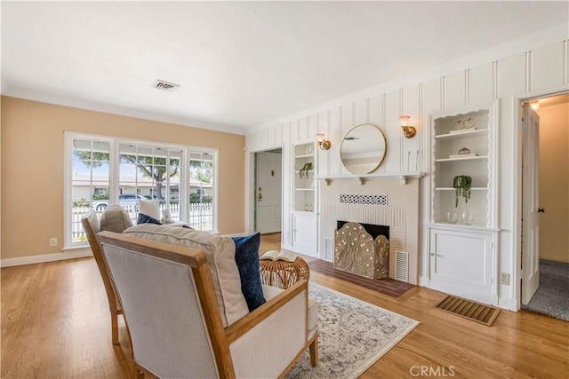 695 W 13th St, Upland, CA 91786 - living room featuring light wood-style floors, a brick fireplace, and ornamental molding