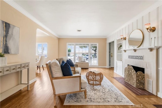 695 W 13th St, Upland, CA 91786 - living room featuring crown molding, light wood-style floors, and a brick fireplace