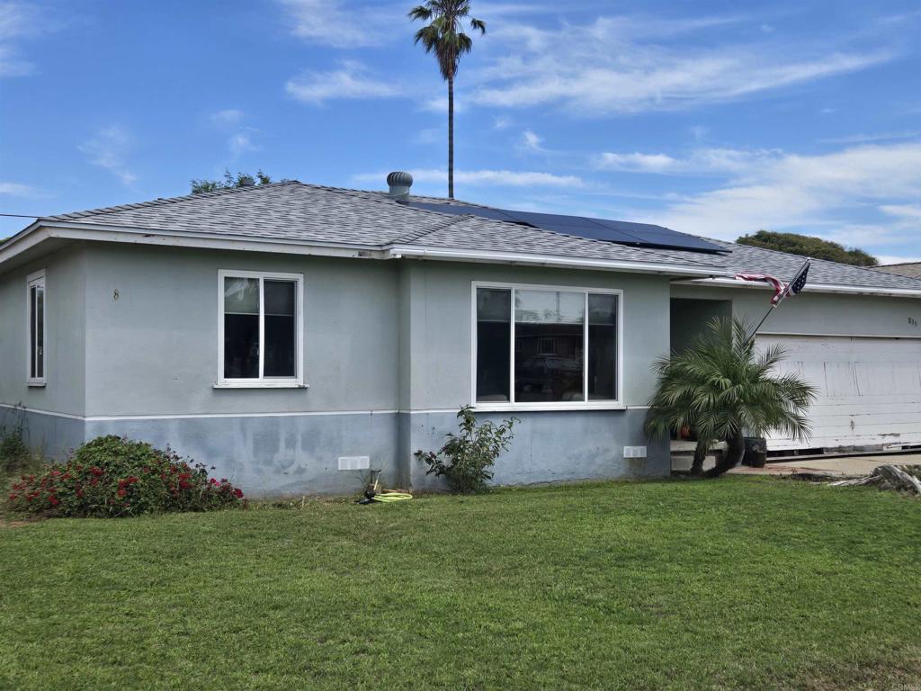 835 Corvina St, Imperial Beach, CA 91932 - view of home's exterior with a shingled roof, a yard, roof mounted solar panels, and stucco siding