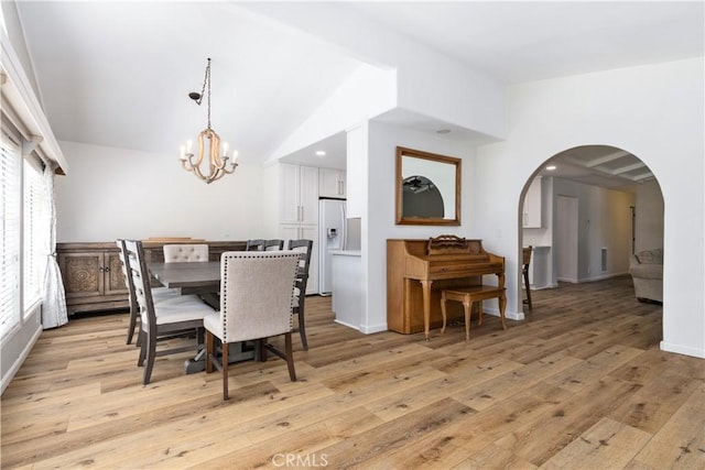 4955 Arizona Ave, Atascadero, CA 93422 - dining room with a chandelier, light wood-type flooring, vaulted ceiling, and arched walkways