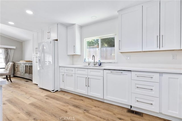 4955 Arizona Ave, Atascadero, CA 93422 - kitchen featuring white refrigerator with ice dispenser, light wood-style floors, white cabinetry, light countertops, and lofted ceiling