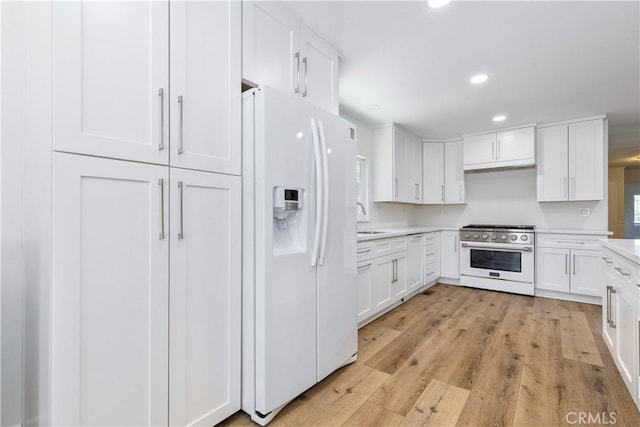 4955 Arizona Ave, Atascadero, CA 93422 - kitchen featuring high end stove, white fridge with ice dispenser, white cabinets, light countertops, and recessed lighting