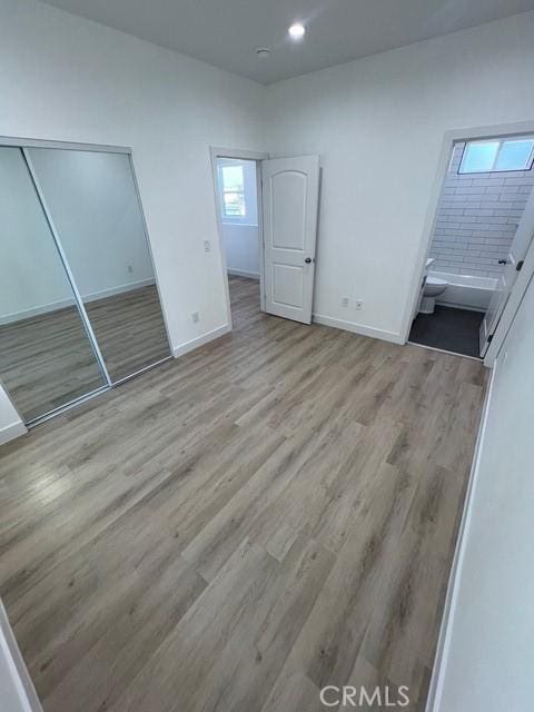1217 E 22nd St, Los Angeles, CA 90011 - unfurnished bedroom featuring wood finished floors, a closet, recessed lighting, and ensuite bath