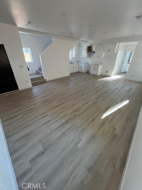 1217 E 22nd St, Los Angeles, CA 90011 - unfurnished living room featuring light wood-style flooring and stairway
