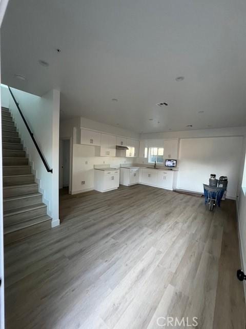 1217 E 22nd St, Los Angeles, CA 90011 - unfurnished living room featuring wood finished floors and stairs