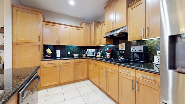 4821 Bakman Ave Unit 405, North Hollywood, CA 91601 - kitchen with stainless steel fridge, gas stovetop, under cabinet range hood, decorative backsplash, and light tile patterned flooring