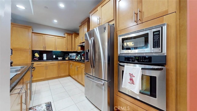 4821 Bakman Ave Unit 405, North Hollywood, CA 91601 - kitchen with appliances with stainless steel finishes, dark countertops, backsplash, light tile patterned floors, and recessed lighting