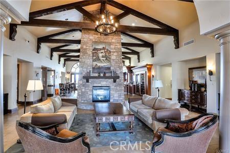3463 Bahia Blanca W Unit B, Laguna Woods, CA 92637 - living area with a fireplace, high vaulted ceiling, beam ceiling, a chandelier, and ornate columns