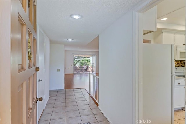 3463 Bahia Blanca W Unit B, Laguna Woods, CA 92637 - hallway with light tile patterned flooring, recessed lighting, and a textured ceiling