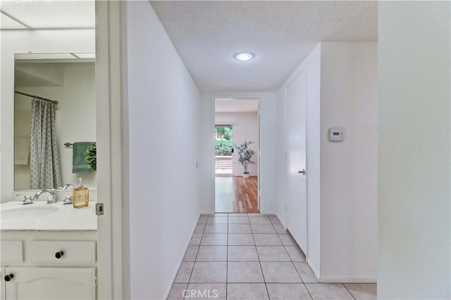 3463 Bahia Blanca W Unit B, Laguna Woods, CA 92637 - hallway with light tile patterned floors and a textured ceiling