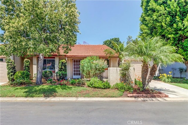 3463 Bahia Blanca W Unit B, Laguna Woods, CA 92637 - view of front of property featuring an attached garage, concrete driveway, stucco siding, and a tiled roof
