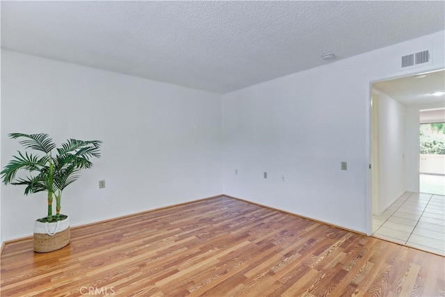 3463 Bahia Blanca W Unit B, Laguna Woods, CA 92637 - spare room with light wood-style floors and a textured ceiling