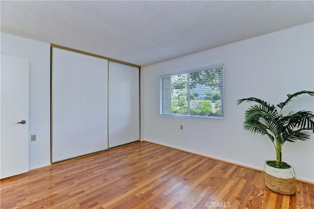 3463 Bahia Blanca W Unit B, Laguna Woods, CA 92637 - unfurnished bedroom featuring wood finished floors, a closet, and a textured ceiling