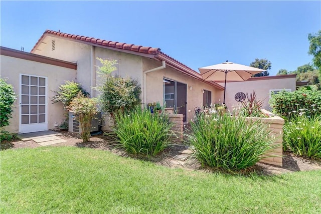 3463 Bahia Blanca W Unit B, Laguna Woods, CA 92637 - rear view of house featuring a yard, a tiled roof, and stucco siding