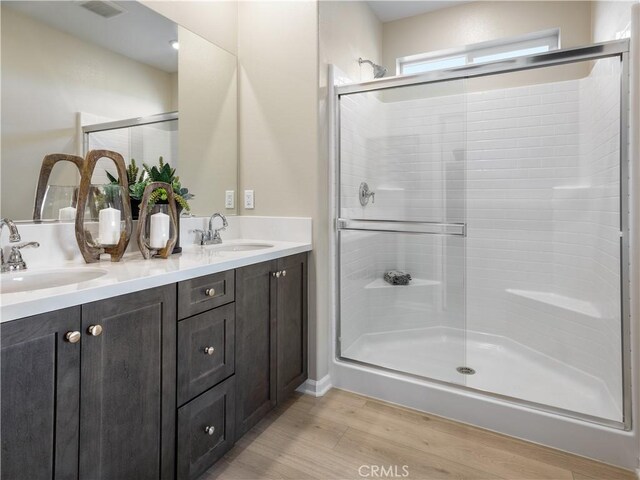 7176 Squall Dr, Riverside, CA 92522 - full bathroom with a stall shower, wood finished floors, and double vanity
