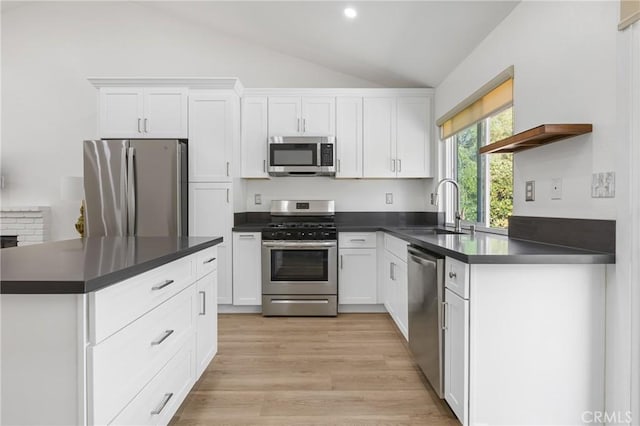 24538 Meadow Grass Way, Moreno Valley, CA 92557 - kitchen featuring appliances with stainless steel finishes, dark countertops, lofted ceiling, white cabinets, and light wood-style floors