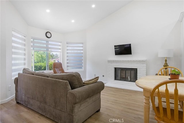 24538 Meadow Grass Way, Moreno Valley, CA 92557 - living area featuring light wood-type flooring, a brick fireplace, and recessed lighting
