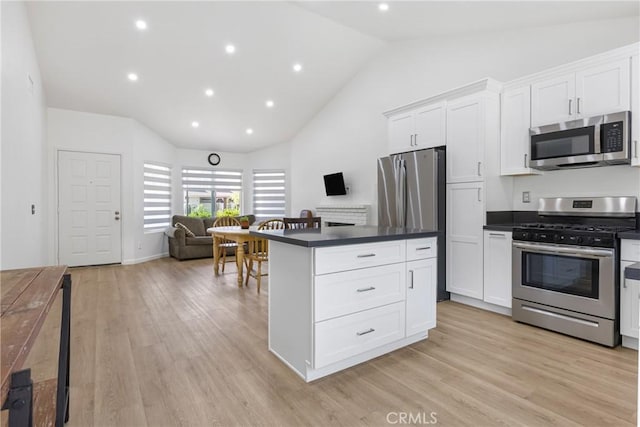24538 Meadow Grass Way, Moreno Valley, CA 92557 - kitchen featuring stainless steel appliances, dark countertops, white cabinets, open floor plan, and light wood-style flooring