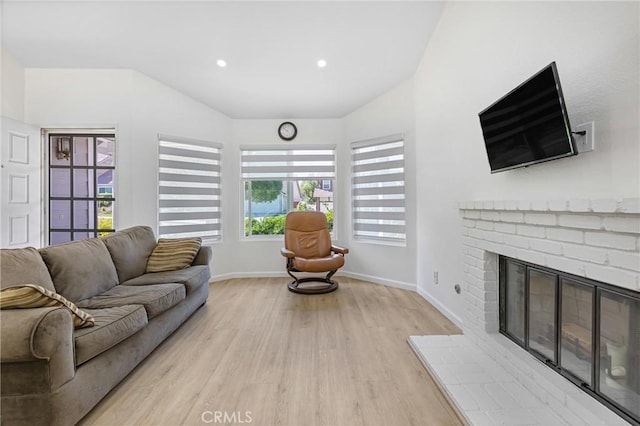 24538 Meadow Grass Way, Moreno Valley, CA 92557 - living area featuring light wood-style flooring, vaulted ceiling, a brick fireplace, and recessed lighting