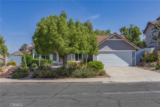 24538 Meadow Grass Way, Moreno Valley, CA 92557 - view of property hidden behind natural elements with an attached garage, a tiled roof, and concrete driveway
