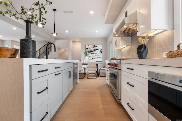 3586 Garfield St, Carlsbad, CA 92008 - kitchen with extractor fan, stainless steel appliances, decorative backsplash, light countertops, and white cabinets