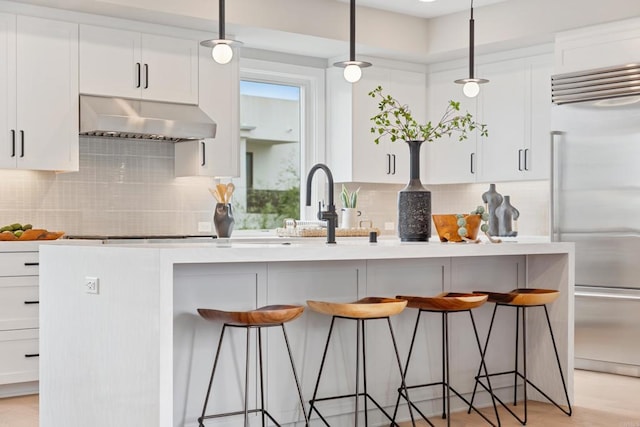 3586 Garfield St, Carlsbad, CA 92008 - kitchen featuring wall chimney exhaust hood, stainless steel built in fridge, a breakfast bar, and white cabinetry