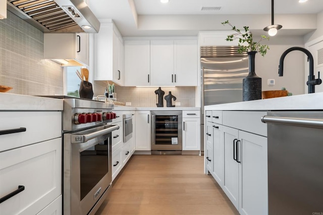 3586 Garfield St, Carlsbad, CA 92008 - kitchen with wine cooler, extractor fan, appliances with stainless steel finishes, light countertops, and decorative backsplash