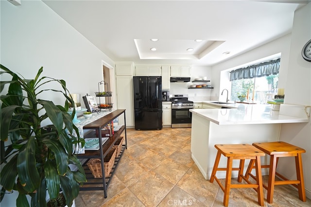 20004 Kent Ln, Canyon Country, CA 91351 - kitchen with gas range, freestanding refrigerator, a peninsula, a tray ceiling, and a breakfast bar area