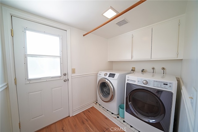 20004 Kent Ln, Canyon Country, CA 91351 - washroom with washing machine and clothes dryer, light wood-type flooring, cabinet space, and wainscoting