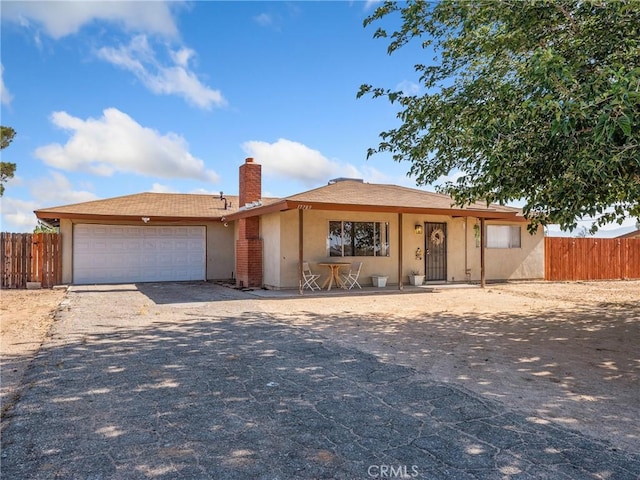 17789 Sycamore St, Hesperia, CA 92345 - ranch-style home with stucco siding, a chimney, a garage, and driveway