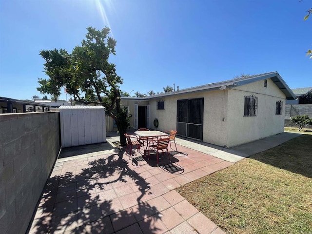 1195 Ilexey Ave, San Diego, CA 92154 - back of property with stucco siding, a patio, a shed, and outdoor dining area