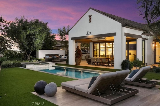 30 Catalina Vista Rd, Ladera Ranch, CA 92694 - back of property at dusk with an exterior structure, an outbuilding, an outdoor hangout area, stucco siding, and an outdoor pool