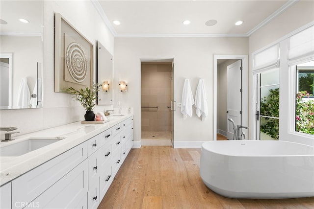 30 Catalina Vista Rd, Ladera Ranch, CA 92694 - bathroom with double vanity, a shower stall, a soaking tub, wood finished floors, and crown molding